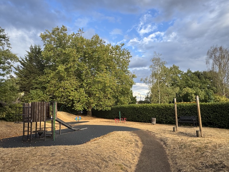 The Grange play area set among trees and hedges